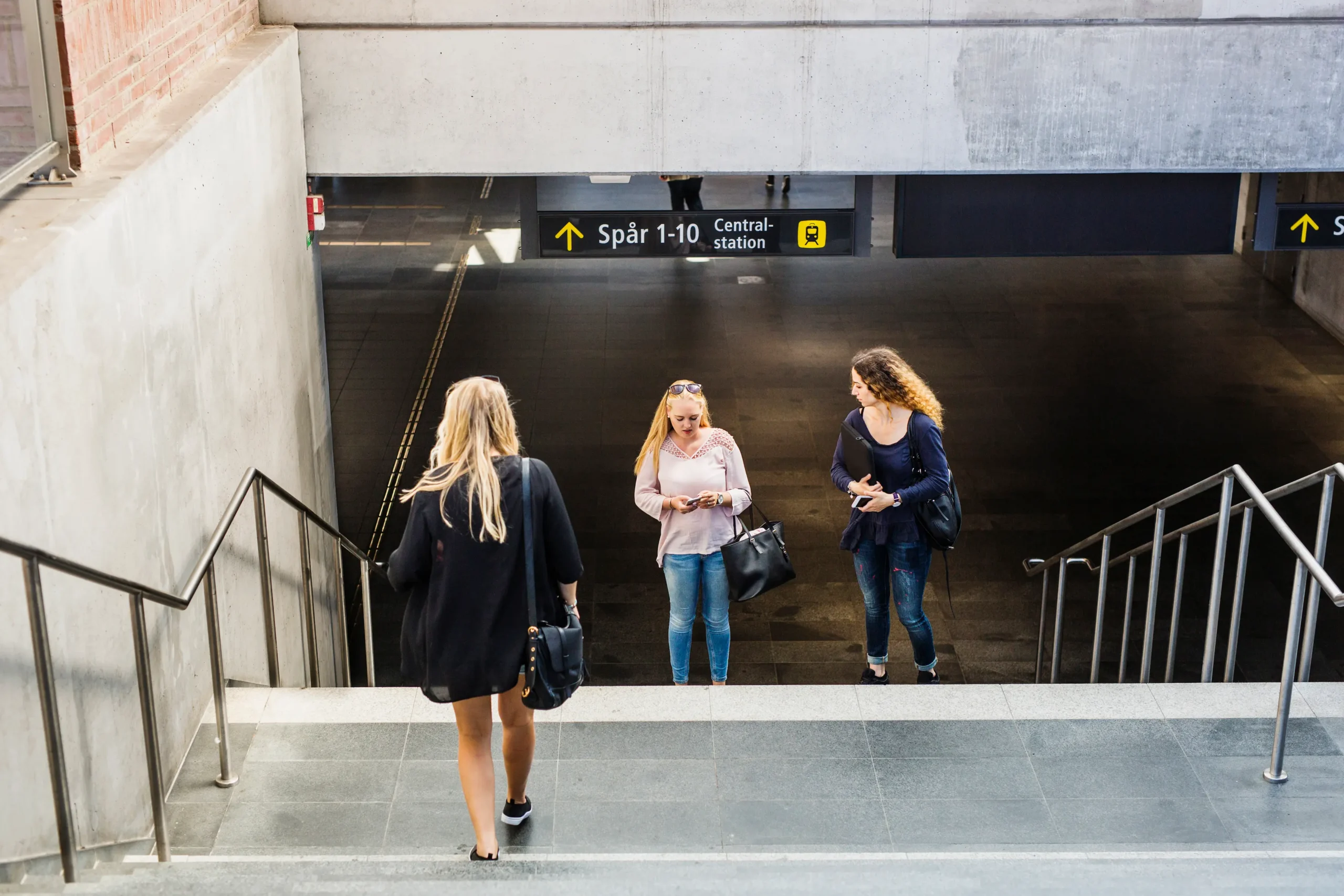 young women standing by stairs in railway station